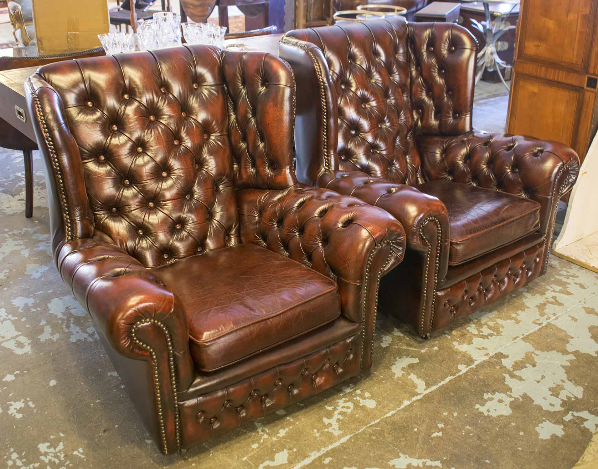 WING ARMCHAIRS, a pair, in buttoned burgundy leather with cushion seats, 93cm W.