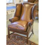WING ARMCHAIR, George III style in close nailed brown leather with cushion seat, 84cm W.