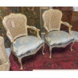 FAUTEUILS, a pair, Louis XV style, painted and giltwood with caned backs and damask seats, 90cm H.