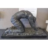 BRONZE KNEELING MALE, on a rectangular black marble platform base,