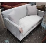 SOFA, two seater, in a silver fabric on square ebonised supports, 131cm L plus a pair of cushions.