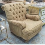 ARMCHAIR, Howard style deep button upholstered with gilt metal castors.