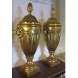 URNS WITH COVERS, a pair, gilt coloured, each with a turned finial, lion mask and swag decoration,