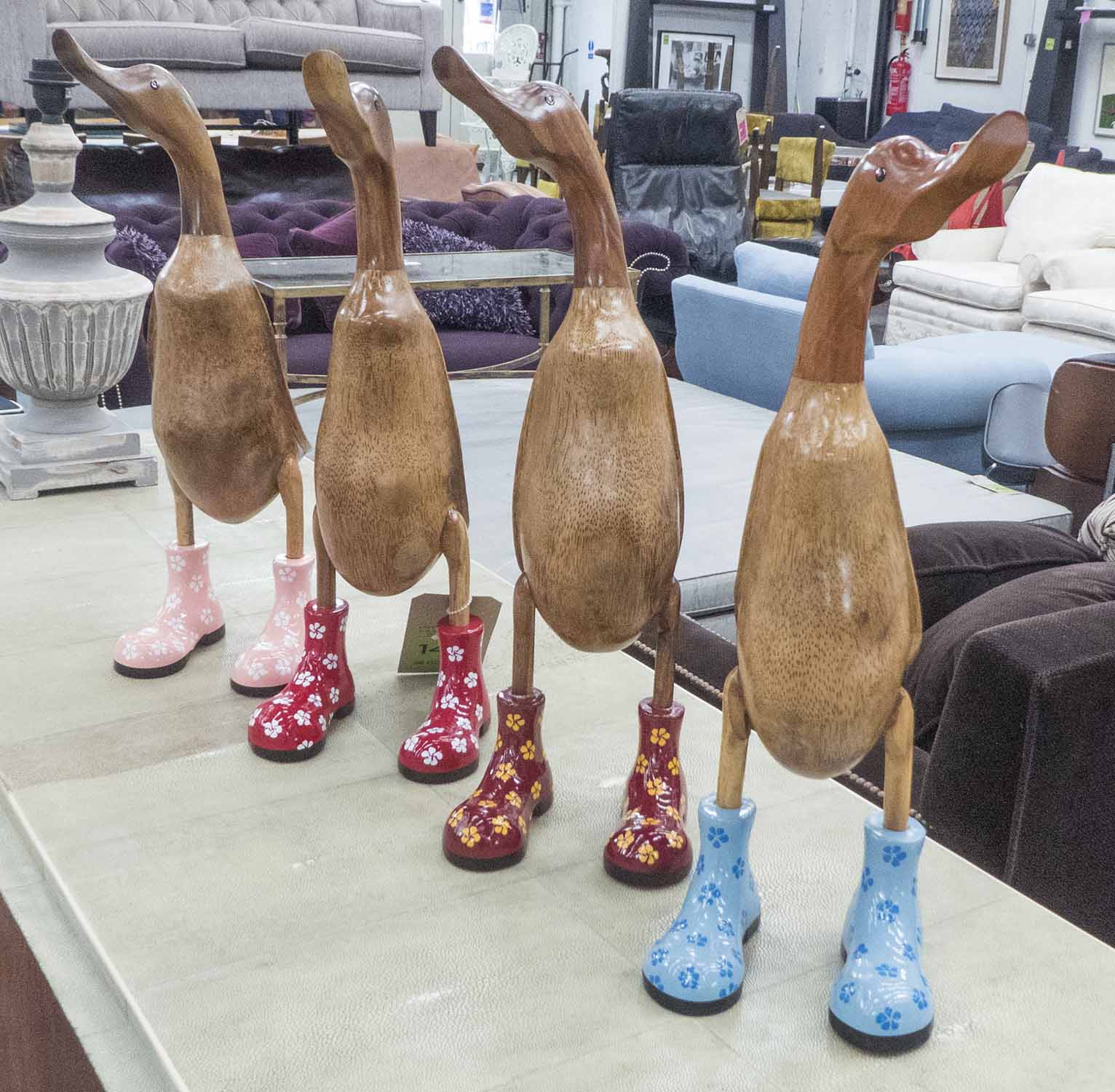 WOODEN 'RUNNER DUCKS', a set of four, carved natural wood, with boots, polished finish, 43cm H.