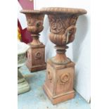 CAMPANA STYLE URNS, terracotta on stands, 59cm D x 130cm H.