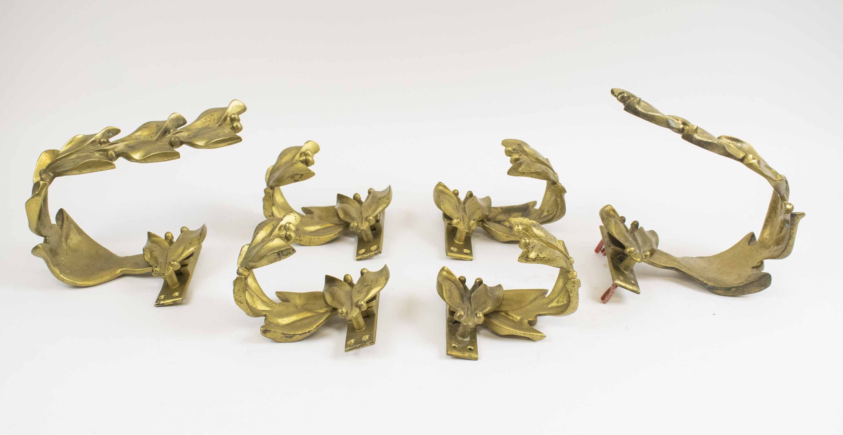 TIE BACKS, a set of six, early 20th century, gilt bronze, comprising two large 26cm W,