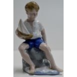 5½" GERMAN PORCELAIN FIGURE OF A YOUNG BOY WITH A MODEL YACHT