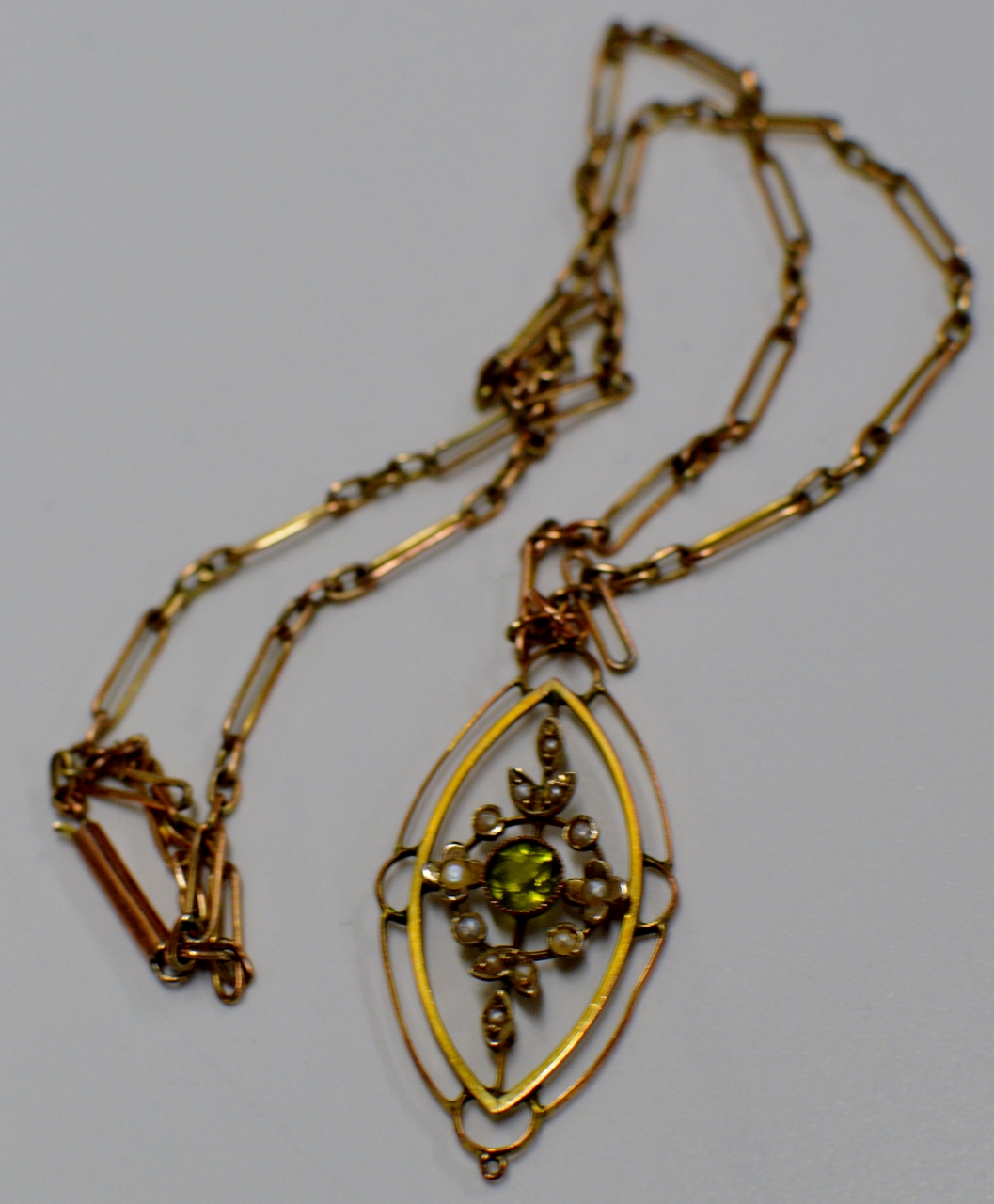 AN ART NOUVEAU STYLE PERIDOT & SEED PEARL SET PENDANT ON 9 CARAT GOLD CHAIN - APPROXIMATE WEIGHT =
