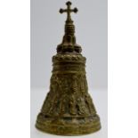 A 7½" HEAVY BRASS ORNATE EASTERN STYLE BELL WITH CROSS FINIAL & DECORATION IN RELIEF