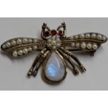 AN UNUSUAL STERLING SILVER BROOCH PIN MODELLED AS A WINGED INSECT, SET WITH A LARGE OPALESCENT
