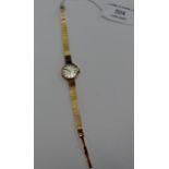 A TISSOT LADIES 9 CARAT GOLD CASED WRIST WATCH ON 9 CARAT GOLD BRACELET - APPROXIMATE WEIGHT = 15.