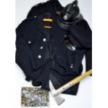 A VINTAGE FIREMAN'S UNIFORM WITH A JACKET, AN OVERCOAT, A HELMET, A HAT, AN AXE & VARIOUS BADGES