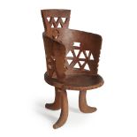 JIMMA CHAIR carved wood, standing on three rounded legs with wrap around backrest 98.5cm high