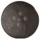 SUDANESE ARAB SHIELD hide shield with four metal bosses, handle on reverse, battle scarred 61.5cm