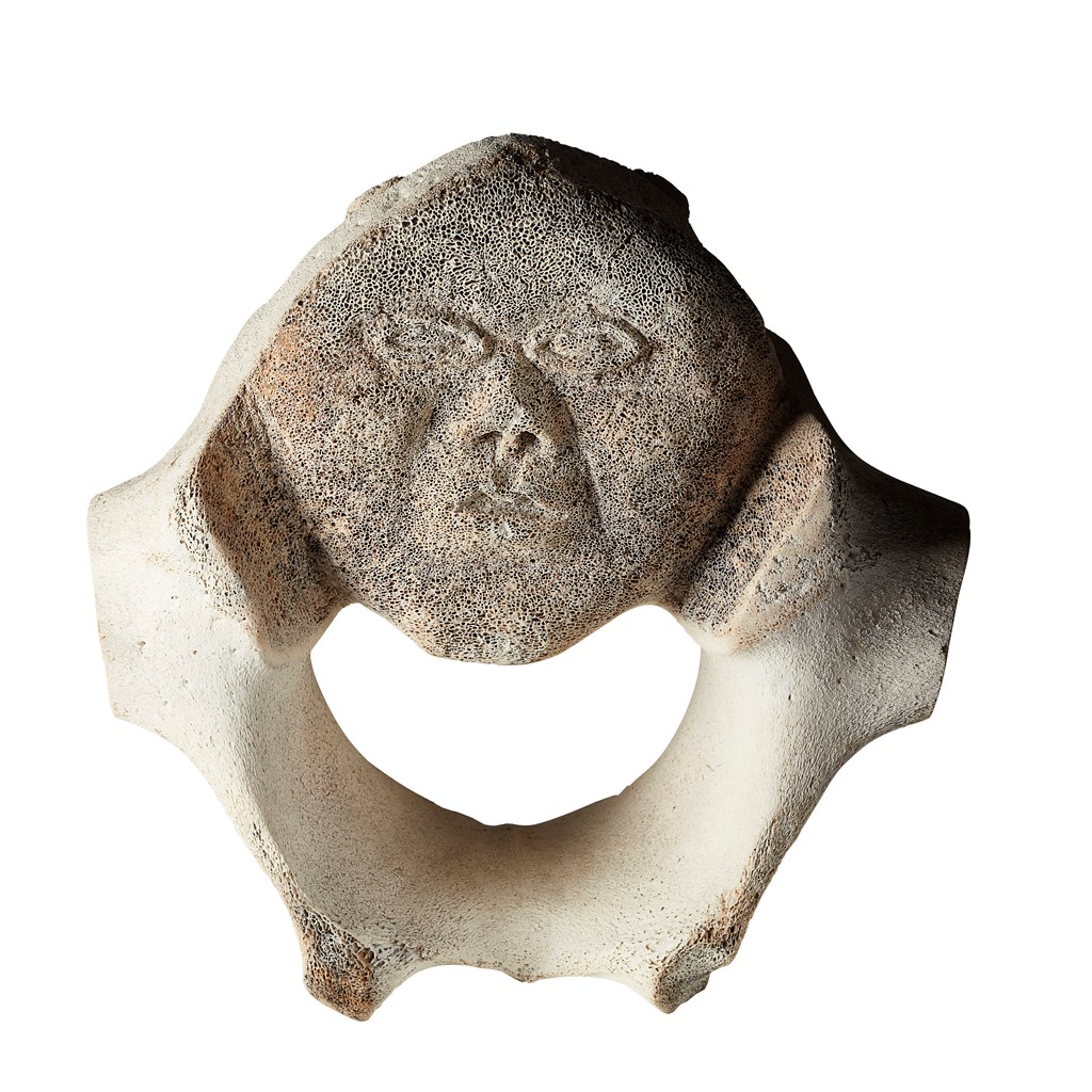 INUIT WHALE VERTEBRAE CARVING carved from a large whalebone vertebrae, with the face of an Inuit man