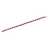 A ruby and diamond set line braceletclaw set with a single row of twenty one oval cut rubies between