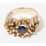 A 1970s 9ct gold sapphire set ringthe textured columnar mount set with a single round cut