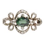 A Belle Époque diamond and tourmaline broochclaw set with an oval cut green tourmaline, in a