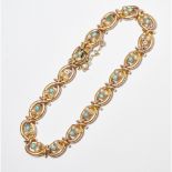 A turquoise and seed pearl set braceletcomposed of a single row oval links, each set with a floral