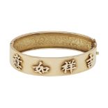 A Chinese export bangleof hinged design, the front with engraved foliate detail, the reverse with