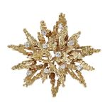 A 1960s 18ct gold diamond set broochmodelled as a stylised sunburst, the textured ground claw set at