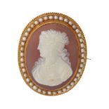 A hardstone cameo and pearl set broochof oval outline, depicting a classical woman in profile, to