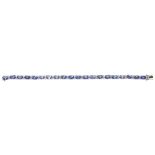 A Tanzanite and diamond set line braceletclaw set with twenty oval-cut Tanzanites between pairs of