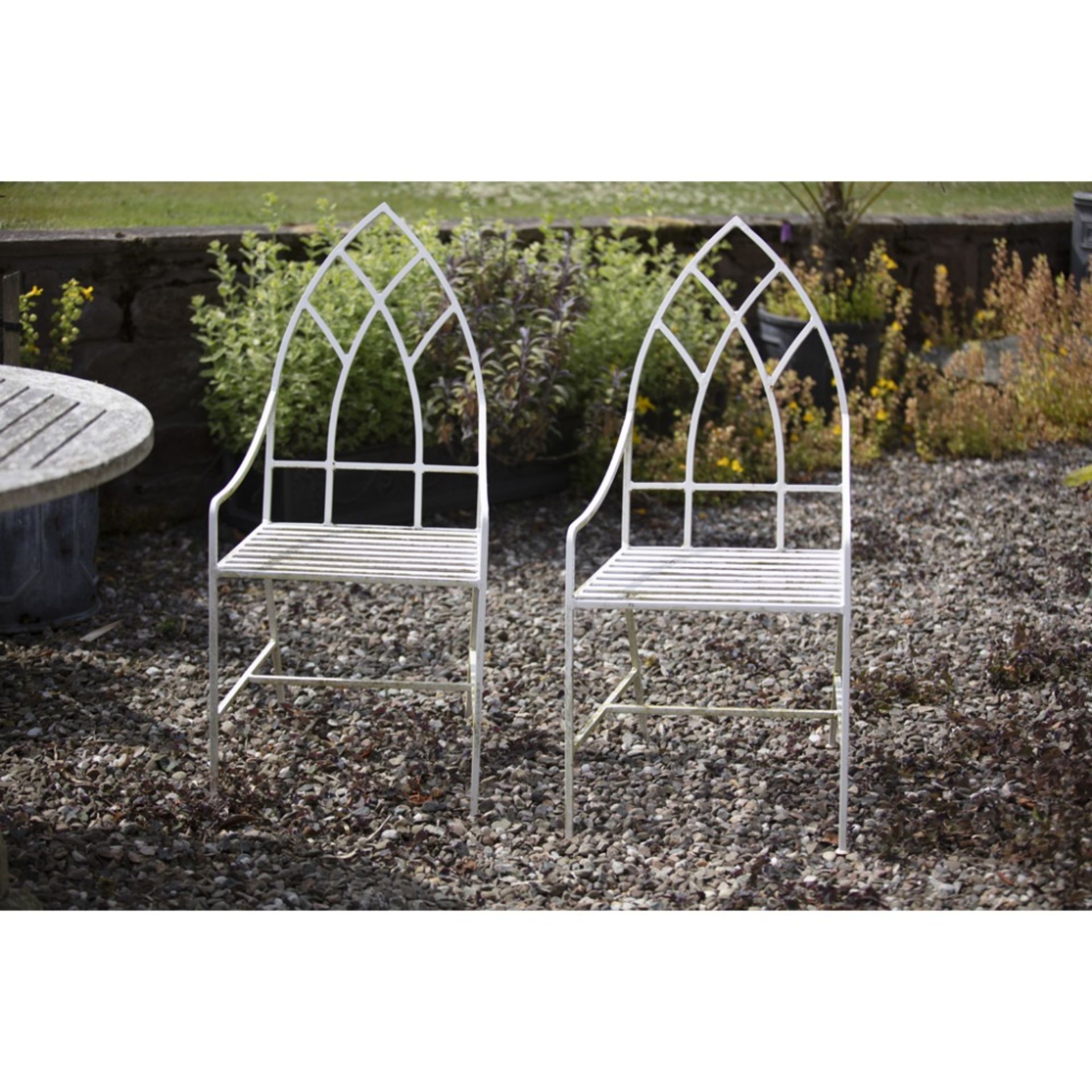 PAIR OF WHITE PAINTED WROUGHT IRON GARDEN CHAIRS MODERN with lancet arch backs above open arms and