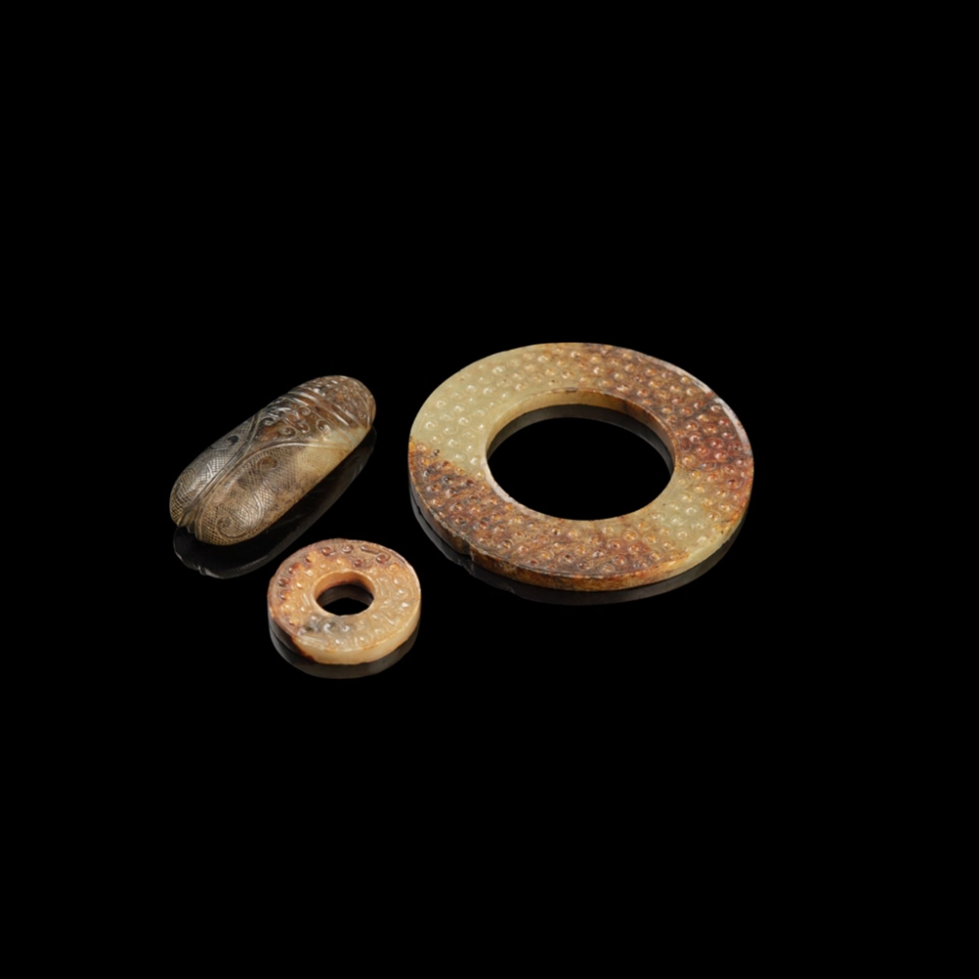 THREE ARCHAISTIC JADE CARVINGScomprising: two bi discs, each finished identically on both sides with