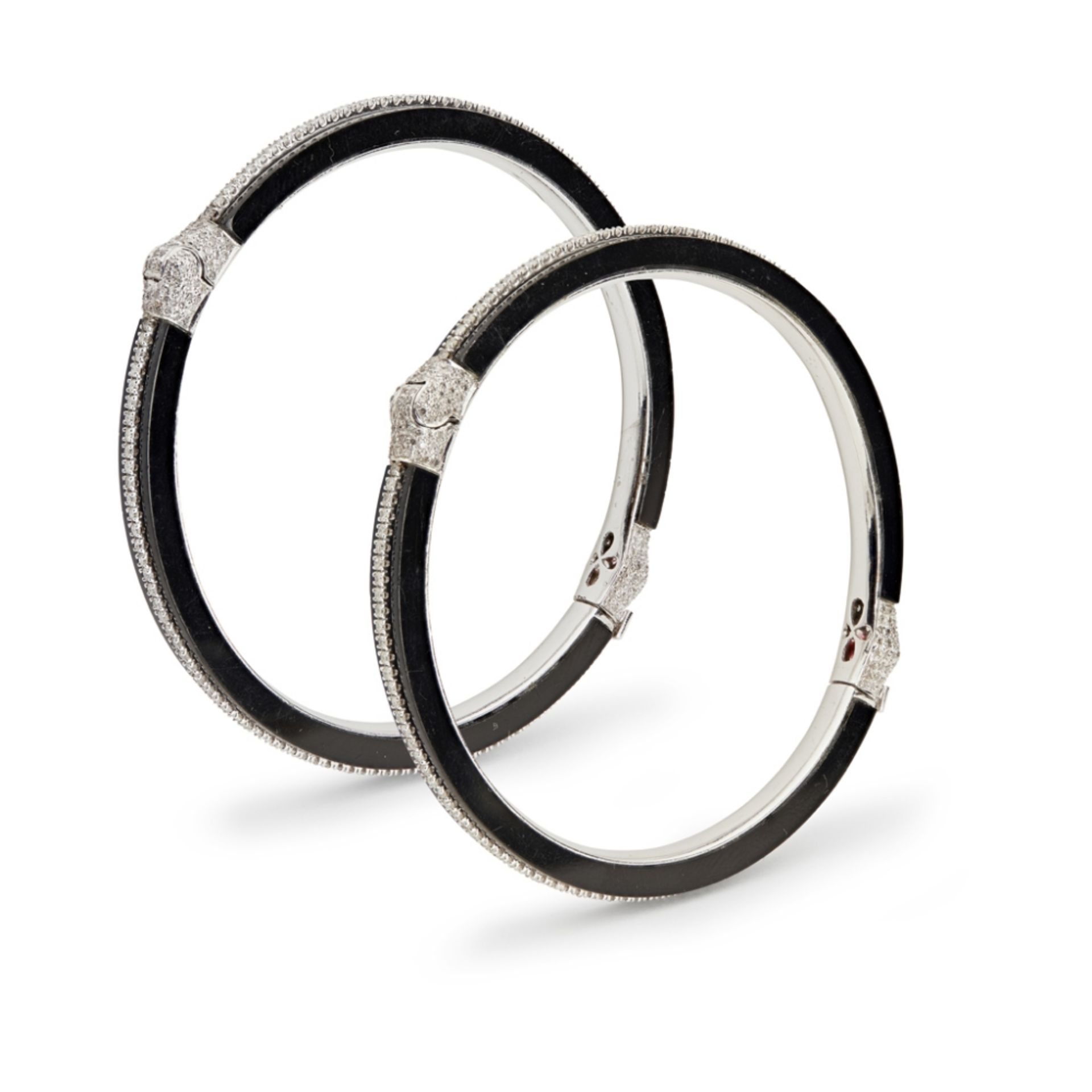 A pair of onyx and diamond set banglesboth of hinged design, set with a single row of small round