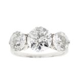 A three stone diamond set ringclaw set with three graduated round cut diamonds, to a plain