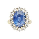 A sapphire and diamond set cluster ringclaw set with an oval cut sapphire, in a border of fourteen