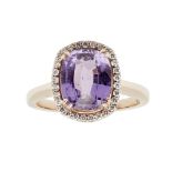 A purple colour-change sapphire and diamond cluster ringclaw set with a cushion cut purple colour-