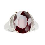 A diamond and ruby ring, by Boodlesclaw set with an oval mixed-cut ruby, flanked to either side by a