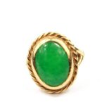 An 18 carat gold ring set with a cabochon jade stone
