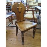 A Victorian oak hall chair, the back of waisted form with blank shield, on turned tapering legs