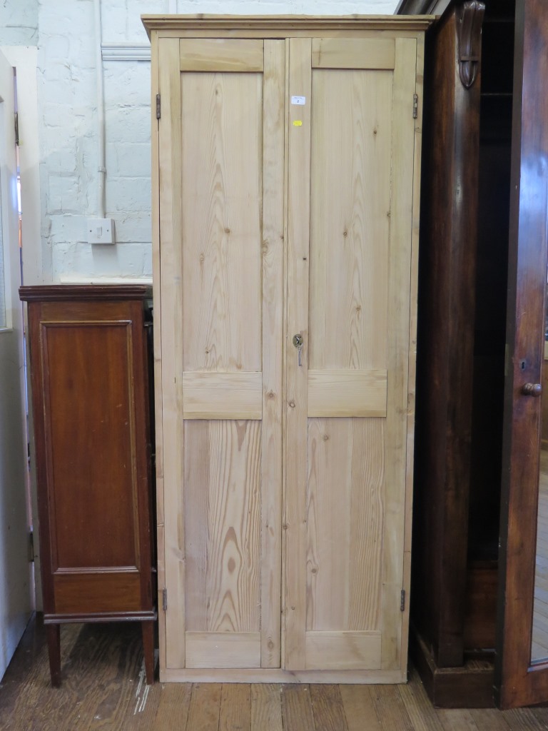 A pine cupboard with twin panelled doors enclosing shelves, 81cm wide, 194.5cm high