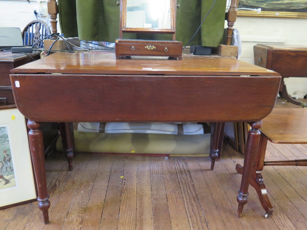 A Victorian mahogany Pembroke table, with drop leaves over a frieze drawer on turned tapering