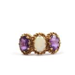 A three stone opal and amethyst ring set in 9 carat gold