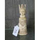 An ethnic tribal carved bone bottle depicting rutting animals, with figural stopper 13.5cm high