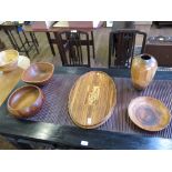 A collection of three teak bowls, a wooden vase and inlaid oval tray