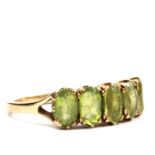 A five stone peridot ring set in 9 carat gold