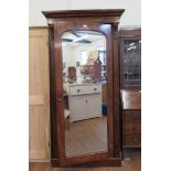 A mid Victorian mahogany wardrobe, the moulded cornice with corbels over a mirrored door on a plinth