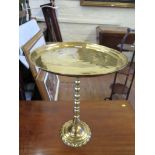 A brass table, the circular top on knopped column stand and circular foot, 50cm high, 39cm diameter