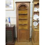 A Georgian style pine display cabinet, with three shaped open shelves in an alcove over a cupboard