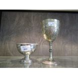 A silver plated goblet decorated in relief together with a small EP bowl on single foot