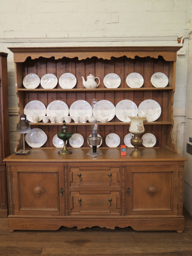 An oak dresser and rack, the two tier rack over a base with two drawers flanked by panelled doors on