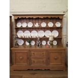 An oak dresser and rack, the two tier rack over a base with two drawers flanked by panelled doors on