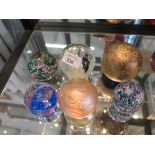 A collection of six various glass paperweights including Caithness, Isle of Wight
