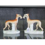 A pair of Staffordshire type greyhound figures, with rabbits in the mouths, 19cm high (2)